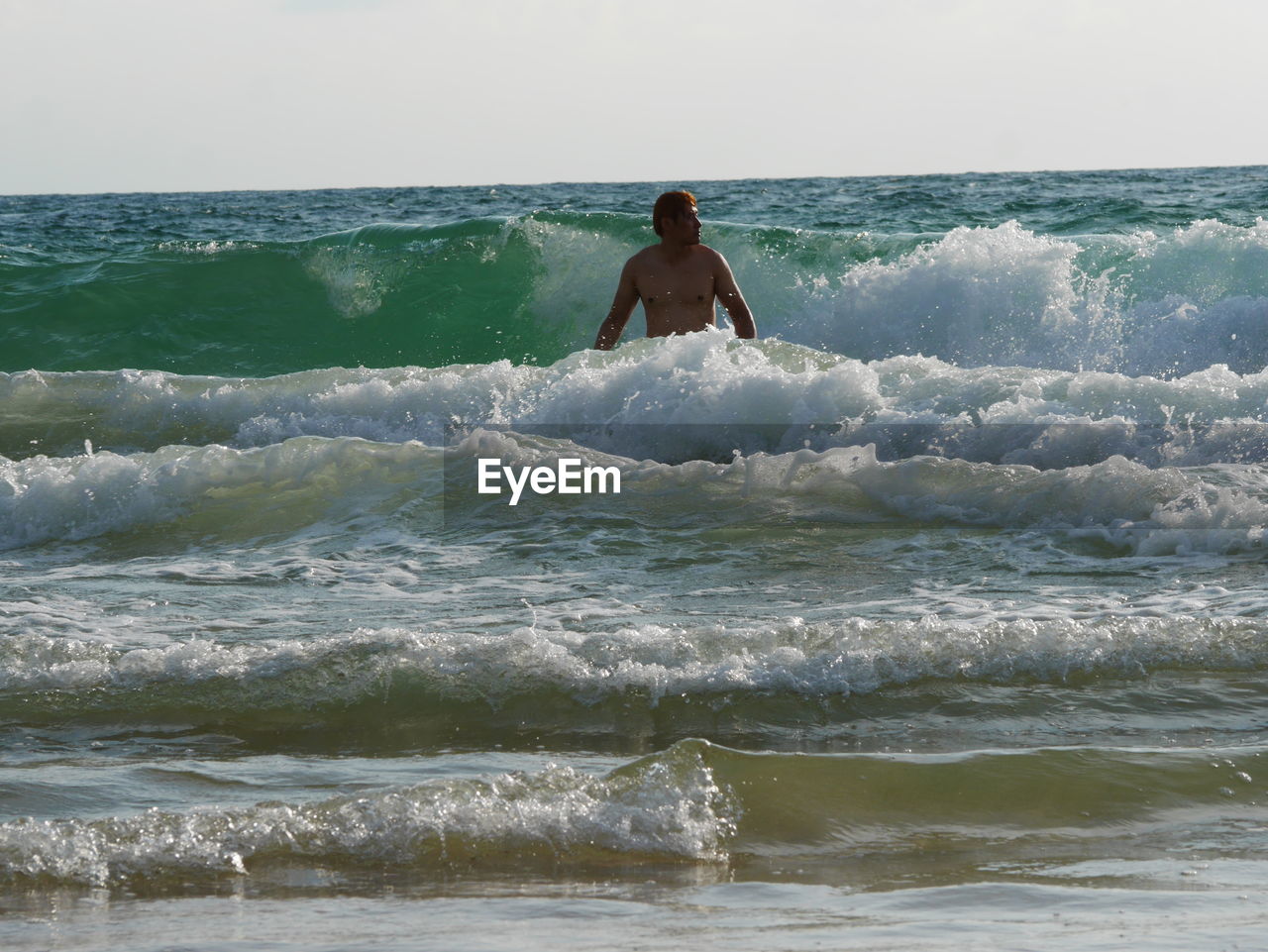 MAN IN SEA AGAINST SKY