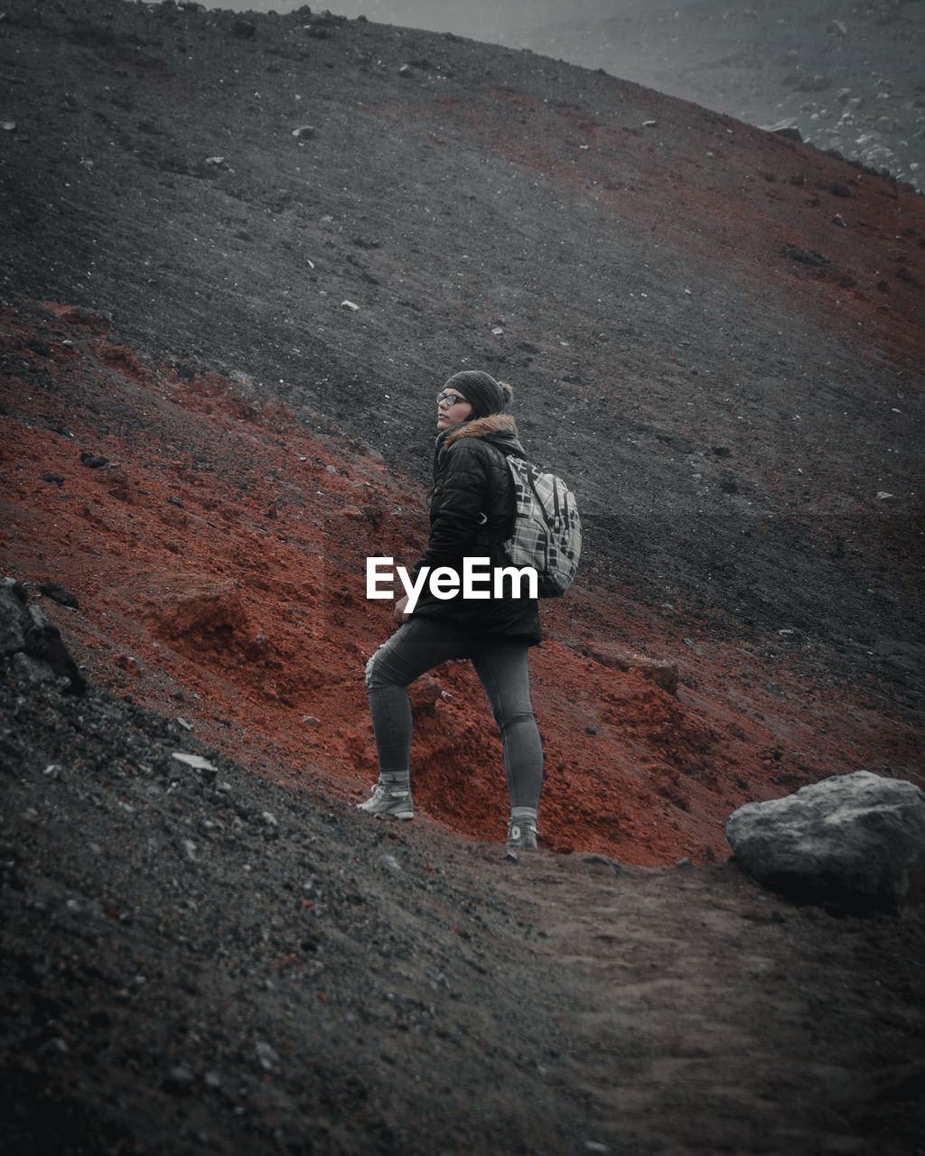 Young woman looking away while standing on mountain