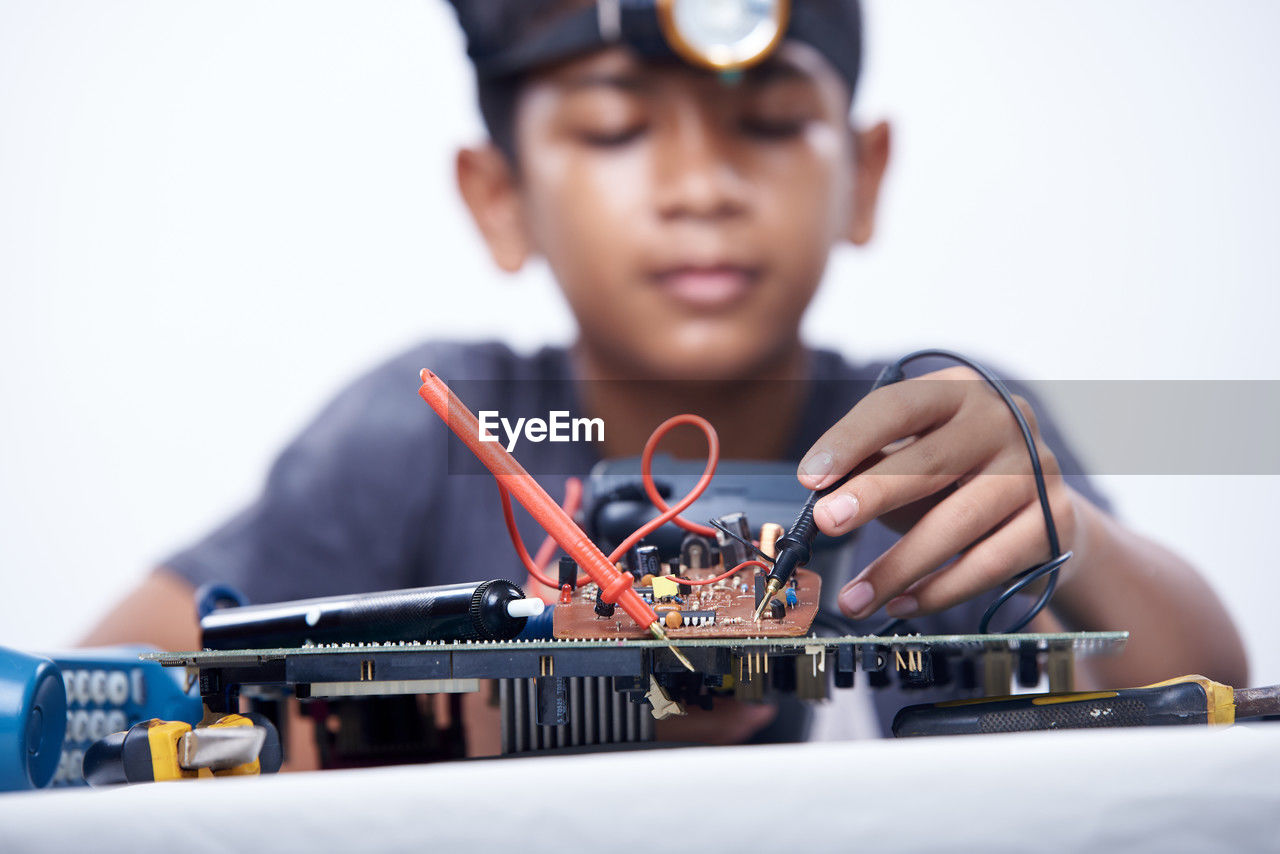 Young schoolboy learning electronic circuit board. detail focus on board component
