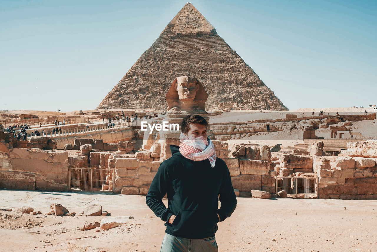 Portrait of man standing against the wonder of the worldpyramids in egypt