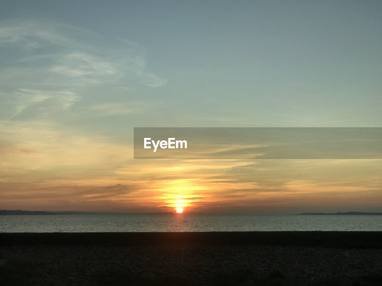 SCENIC VIEW OF BEACH AGAINST SKY DURING SUNSET