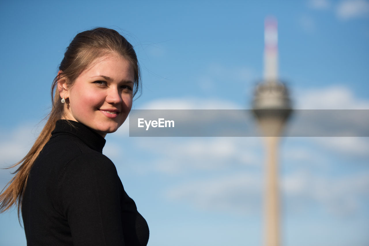 Portrait of smiling young woman with fernsehturm in background