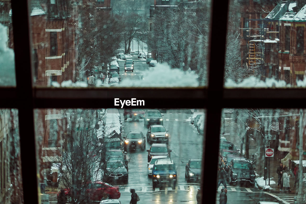 Cars on road seen through glass window