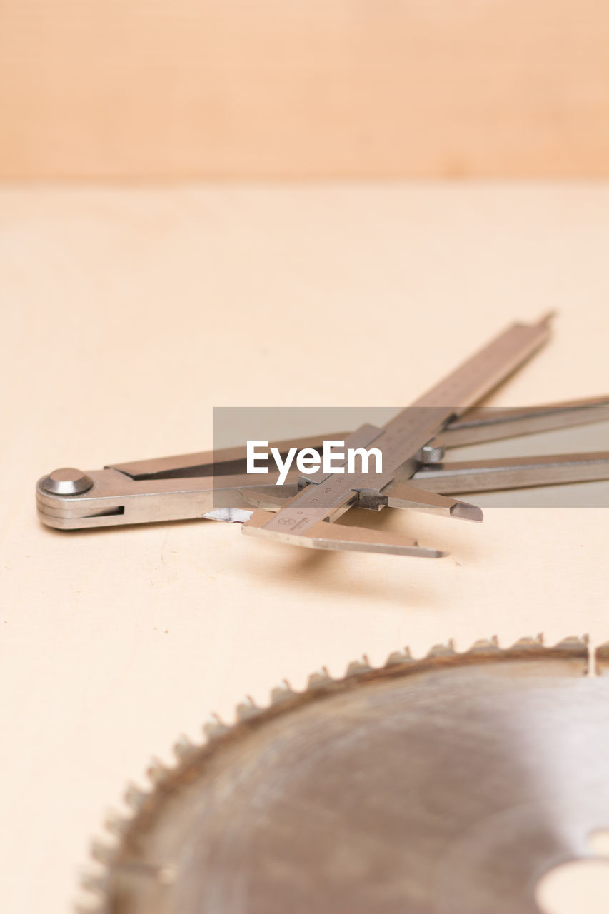 Close-up of saw blade and work tool on table