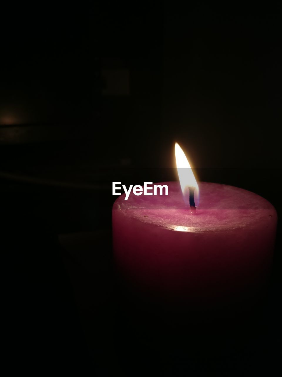 CLOSE-UP OF ILLUMINATED CANDLE