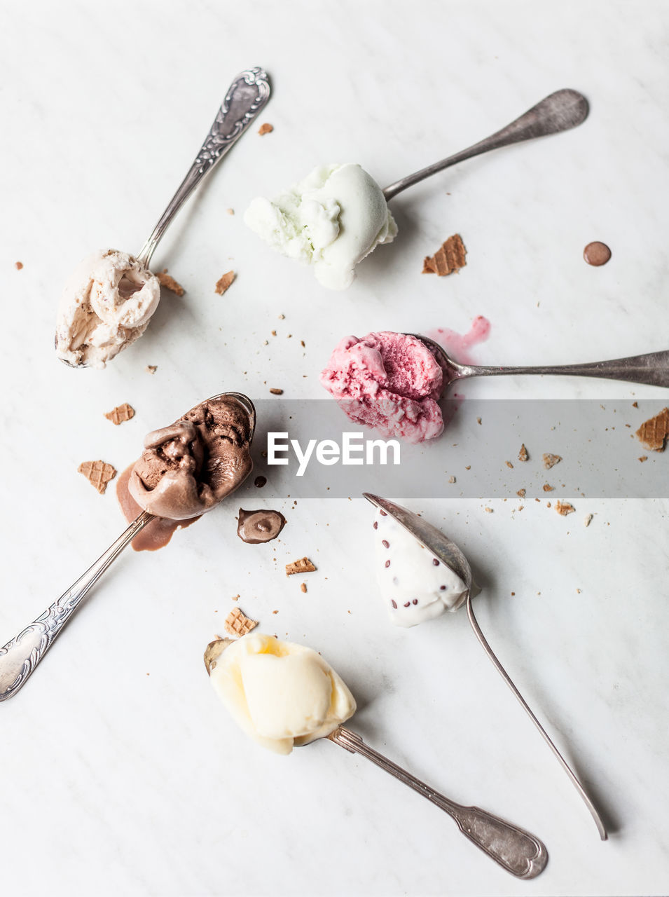 High angle view of spoons with ice cream on table