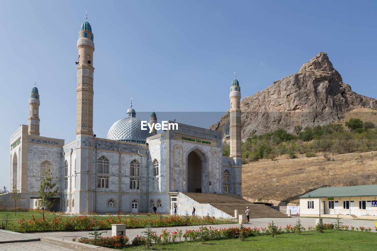 architecture, religion, built structure, travel destinations, building exterior, place of worship, historic site, building, travel, belief, landmark, sky, nature, tourism, spirituality, dome, history, the past, plant, blue, clear sky, landscape, outdoors, city, no people, grass, sunny