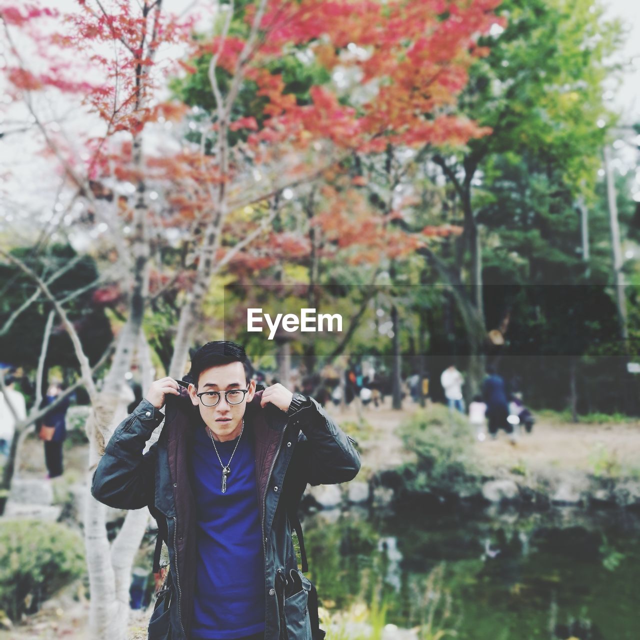 Portrait of young man standing against plants