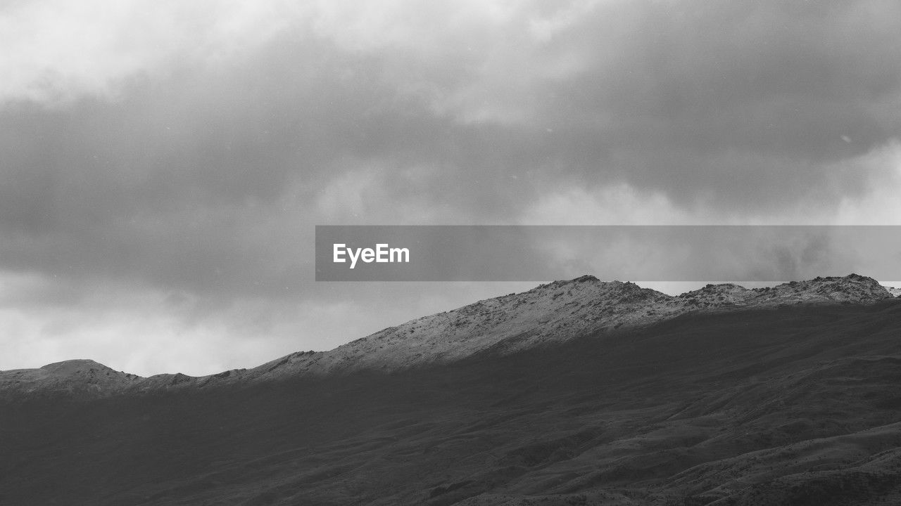 mountain, environment, cloud, snow, landscape, black and white, sky, scenics - nature, beauty in nature, monochrome, mountain range, monochrome photography, land, nature, no people, dramatic sky, storm, travel destinations, travel, overcast, non-urban scene, outdoors, cold temperature, tourism, mountain peak, fog, tranquility, horizon, winter, storm cloud, ridge