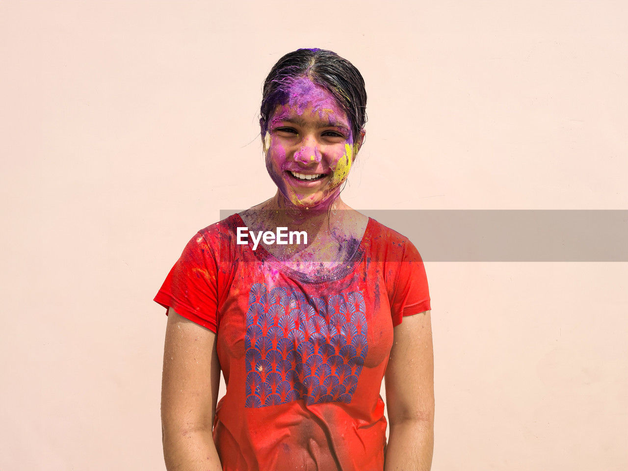 Portrait of happy indian girl celebrating holi with powder colours or gulal. indian festival holi.