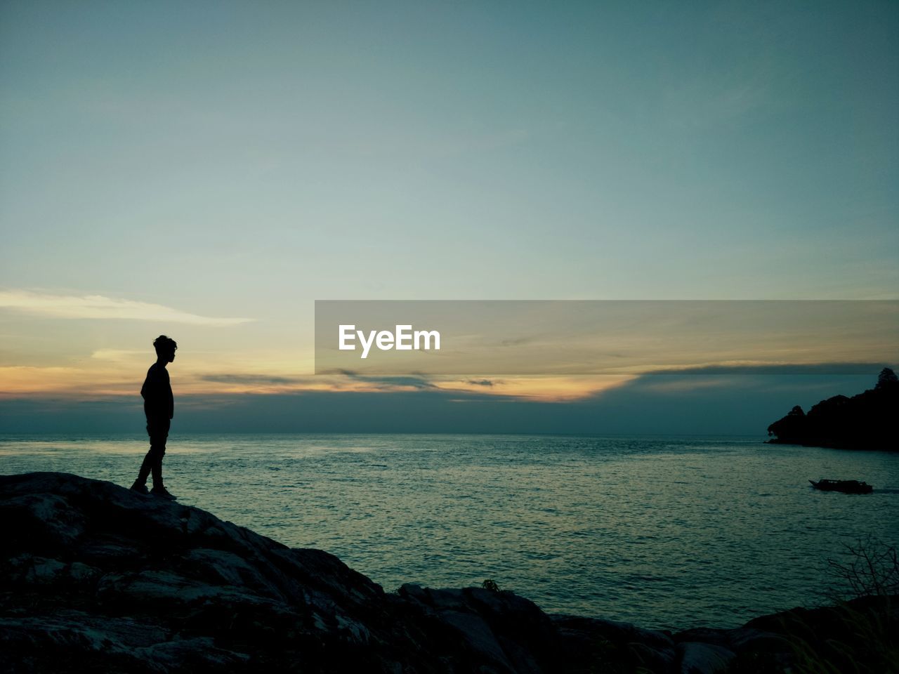 SILHOUETTE MAN LOOKING AT SEA AGAINST SKY AT SUNSET
