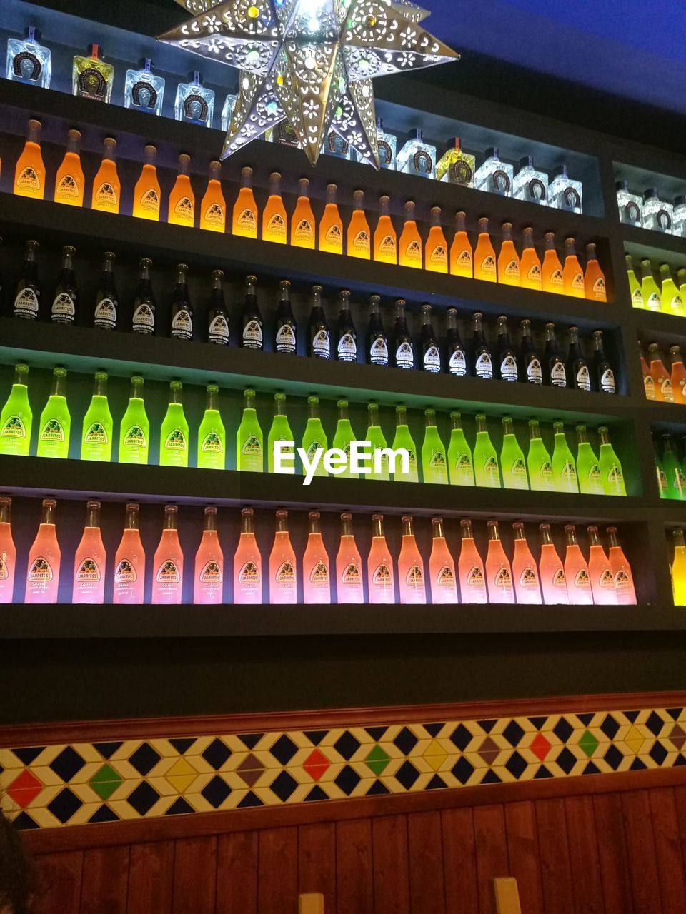 LOW ANGLE VIEW OF MULTI COLORED BOTTLES