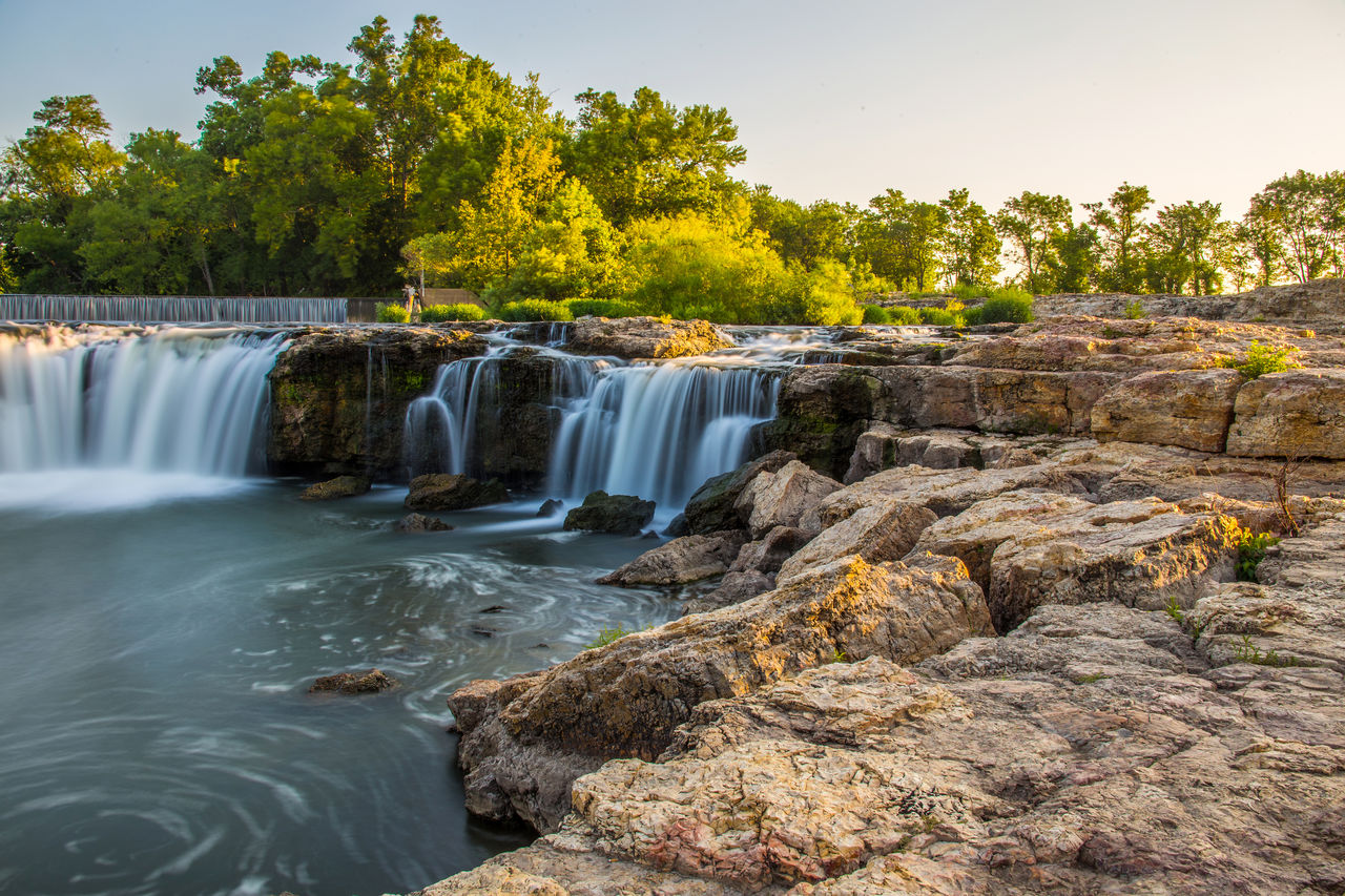 waterfall, water, body of water, scenics - nature, environment, nature, tree, beauty in nature, river, water feature, plant, motion, rock, landscape, travel destinations, travel, flowing water, flowing, land, environmental conservation, long exposure, tourism, sky, autumn, forest, outdoors, no people, social issues, watercourse, non-urban scene, vacation, trip, holiday, water resources, stream, rapid, idyllic, tropical climate