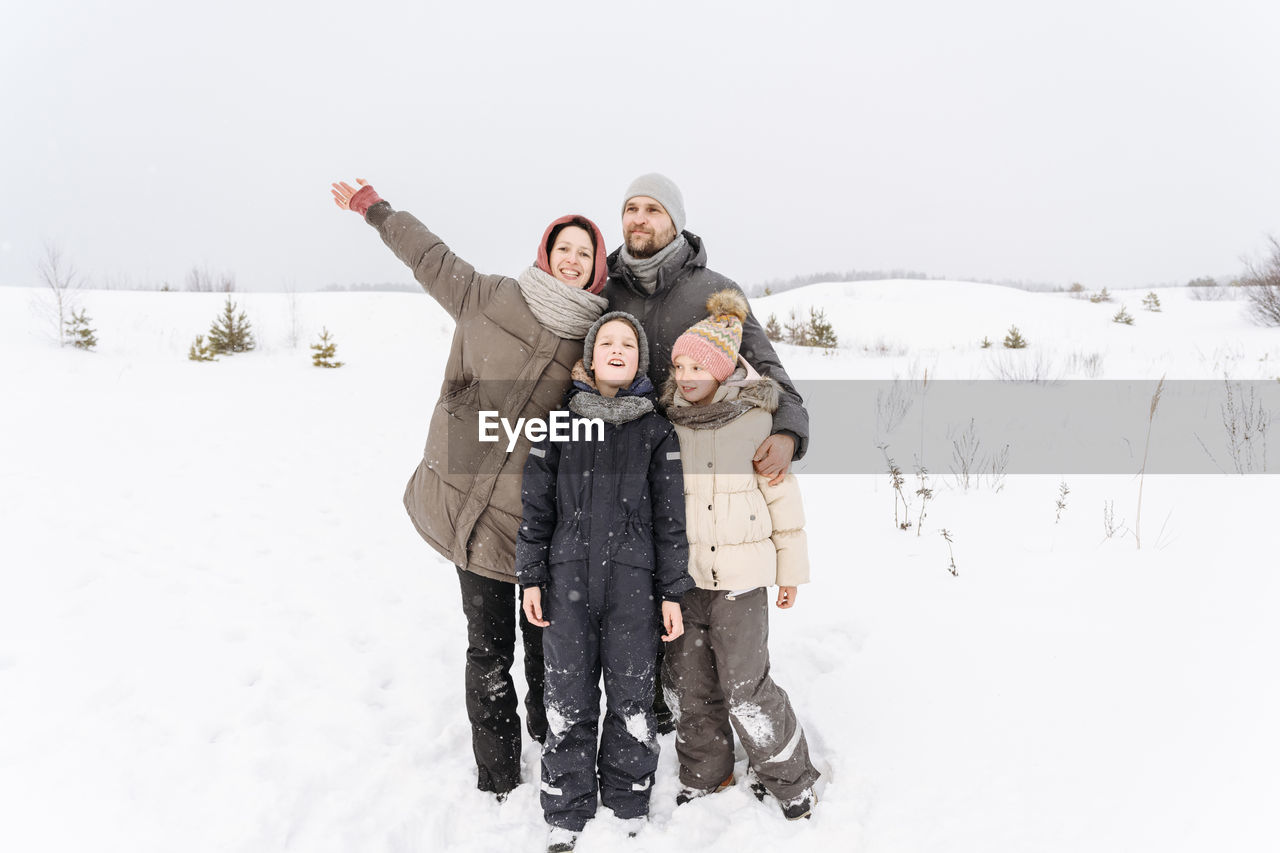 Family enjoying vacations together on snow covered landscape