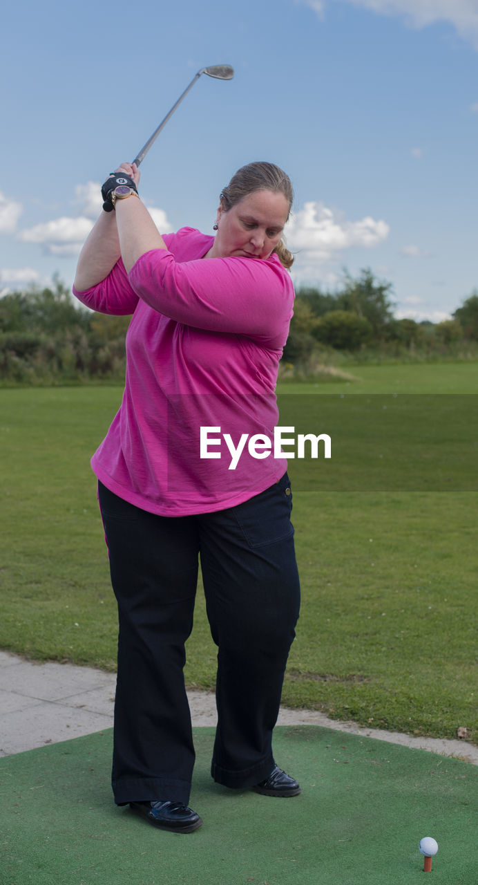 Full length of woman playing golf on field