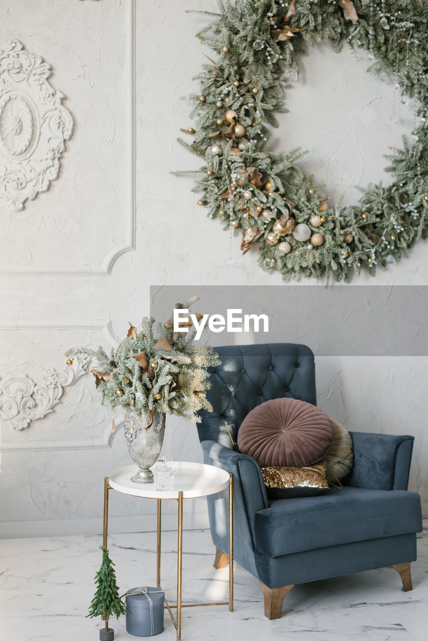 Classic christmas living room interior. a blue armchair with pillows, a wreath on the wall