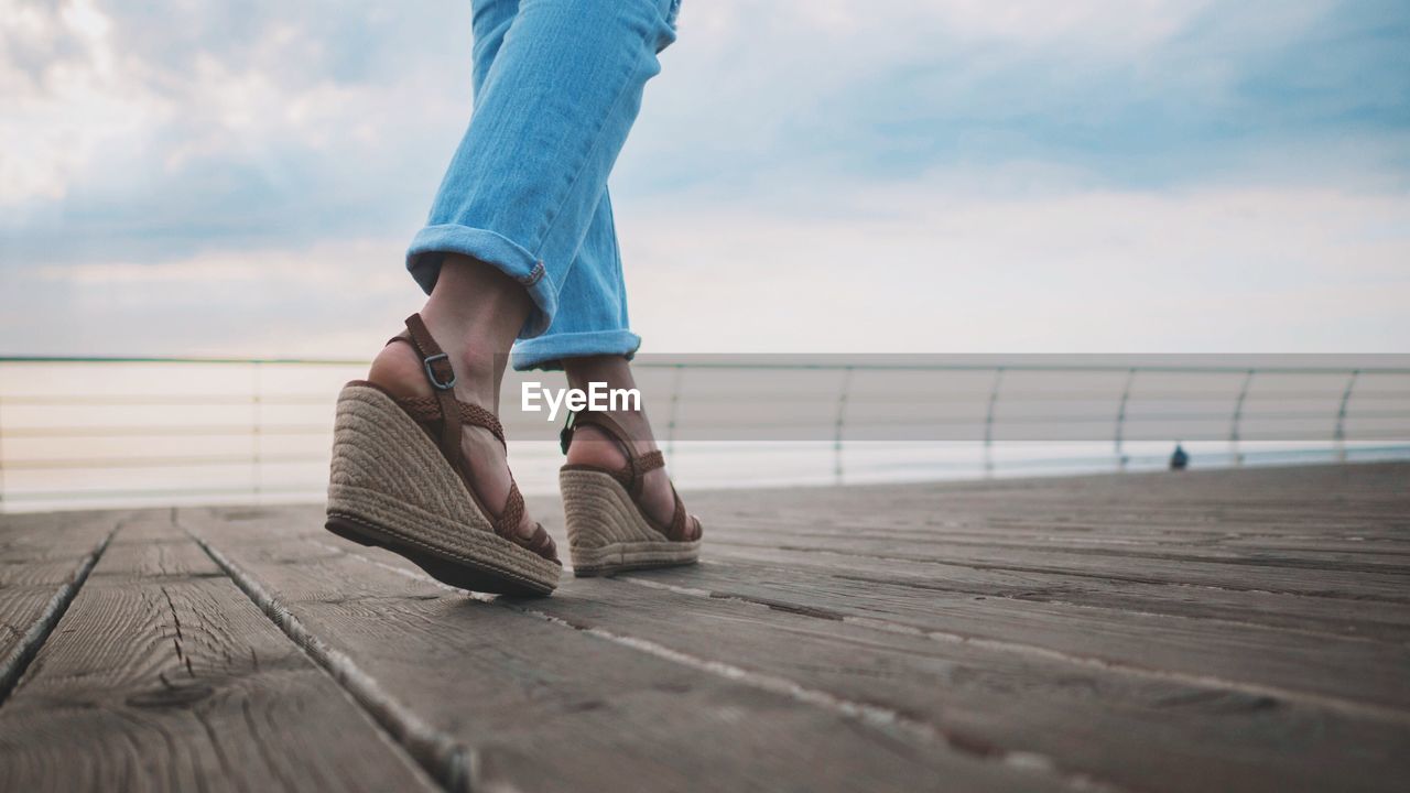 Low section of woman standing on pier