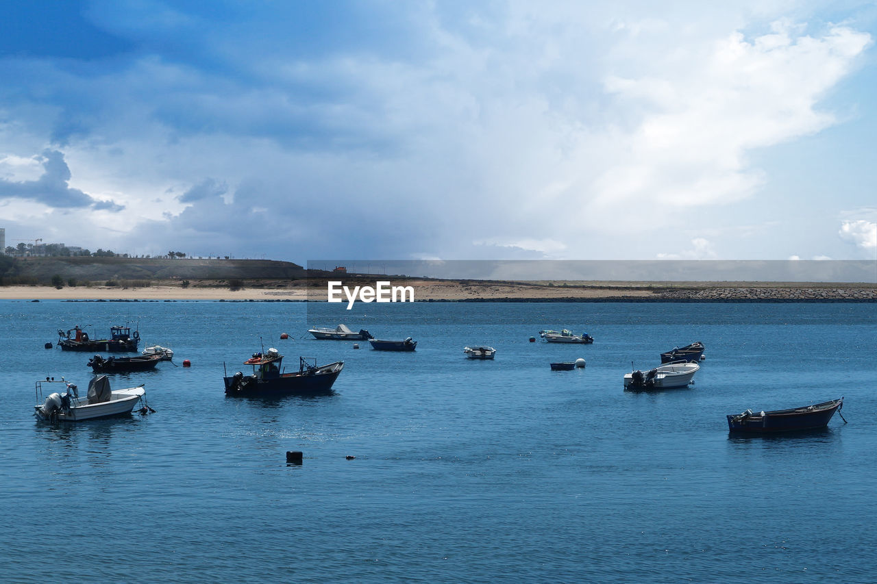 Boats sailing on sea against sky