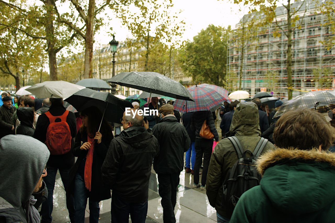 Rear view of people with umbrella in rain