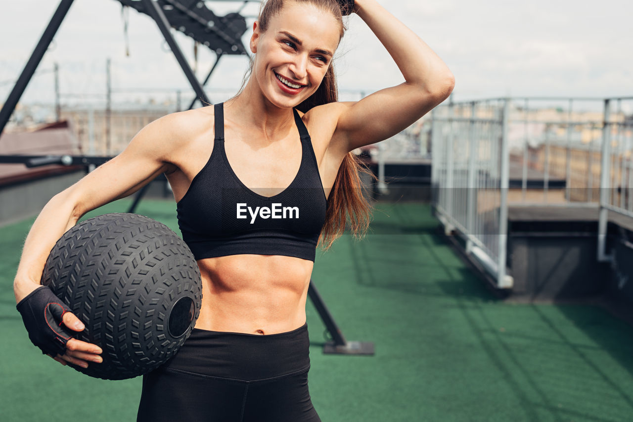 Woman exercising with ball while standing in gym