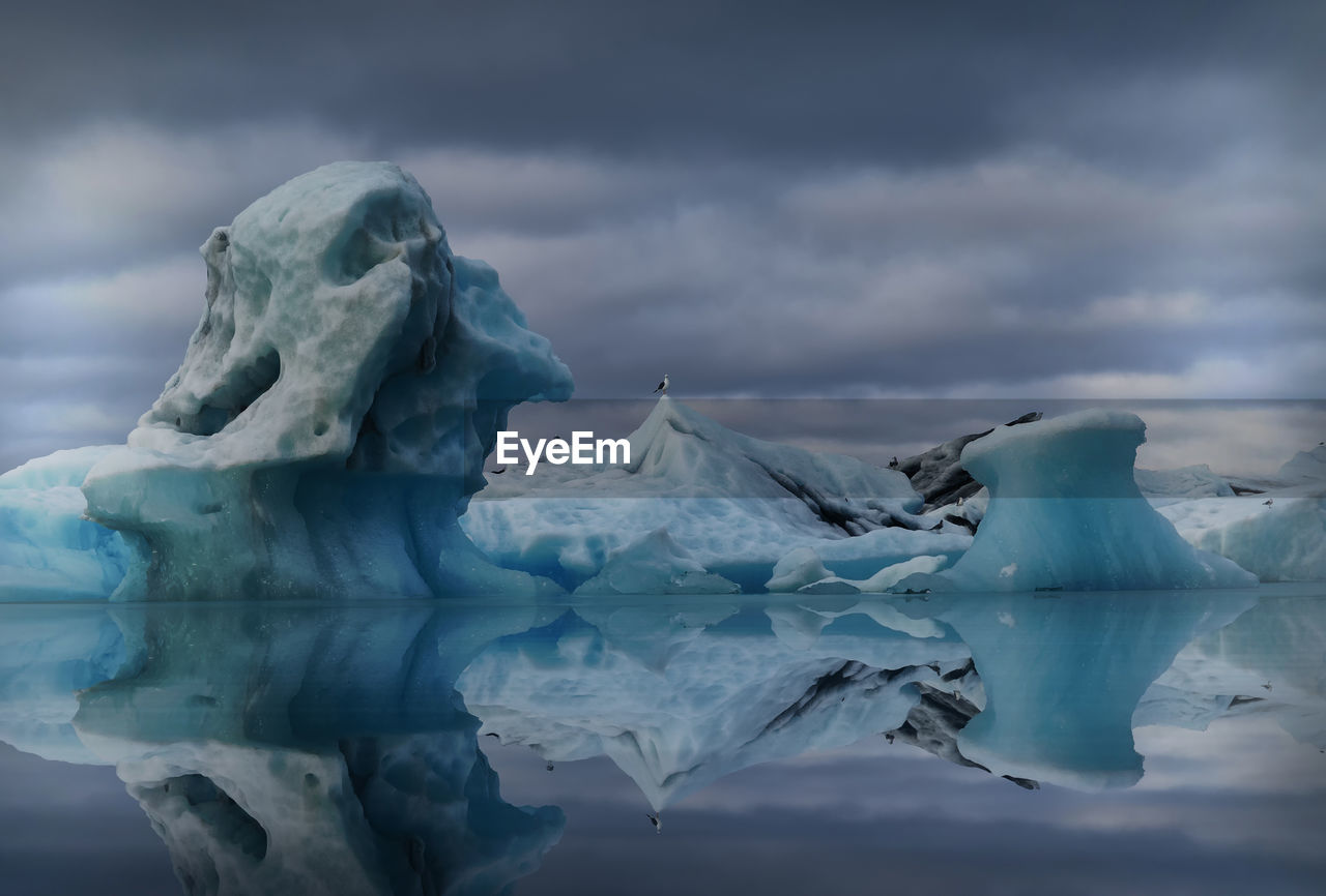 Frozen lake against cloudy sky during winter