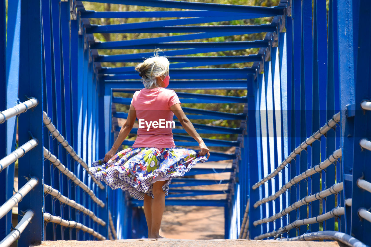 Rear view of woman on footbridge