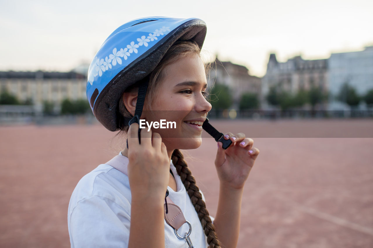 A child in a helmet gets ready for a bike adventure, the focus on safety and support