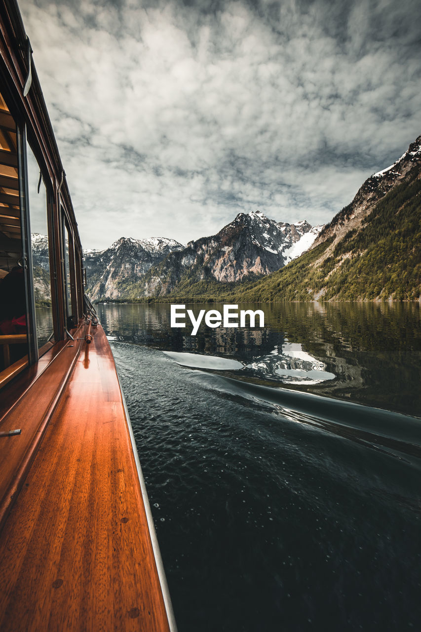 Scenic view of lake by mountains against sky