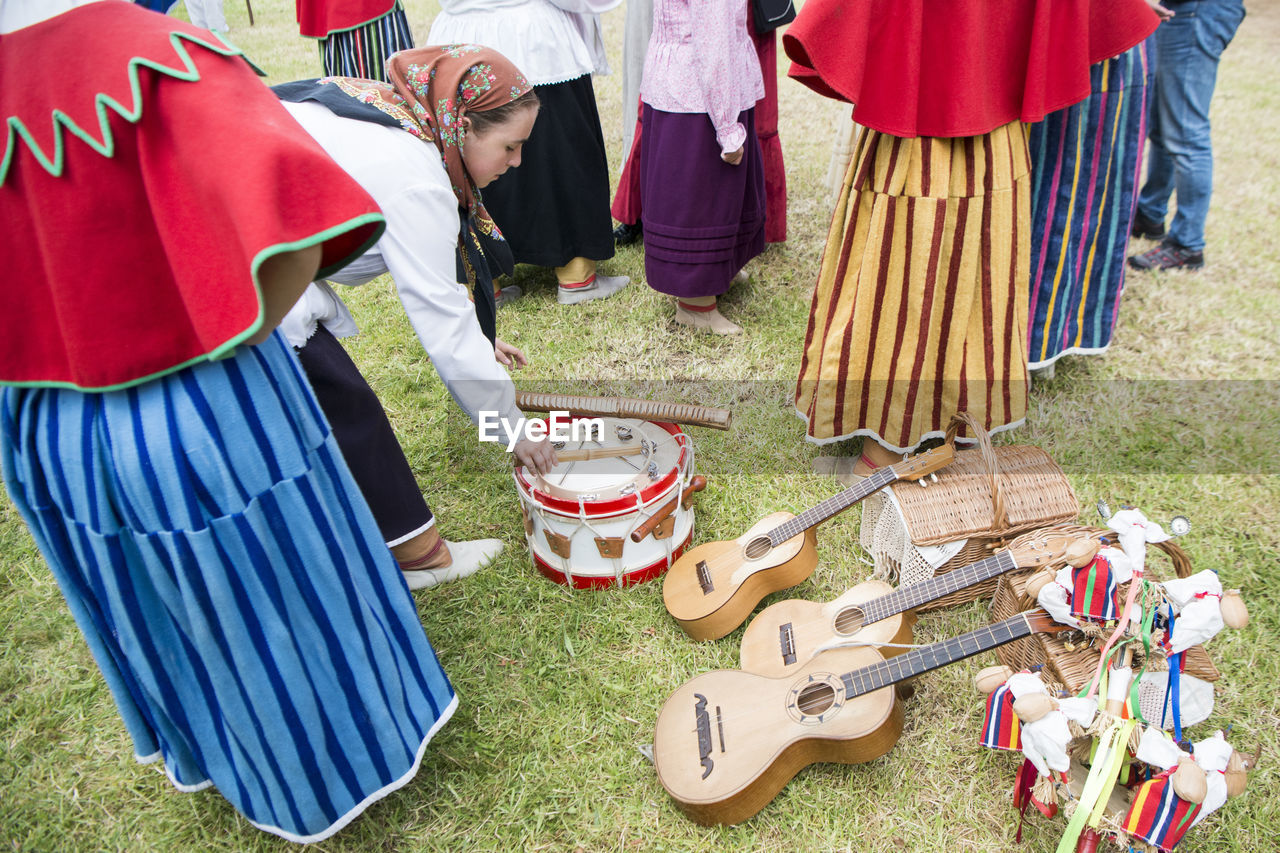 HIGH ANGLE VIEW OF PEOPLE STANDING ON GRASSLAND