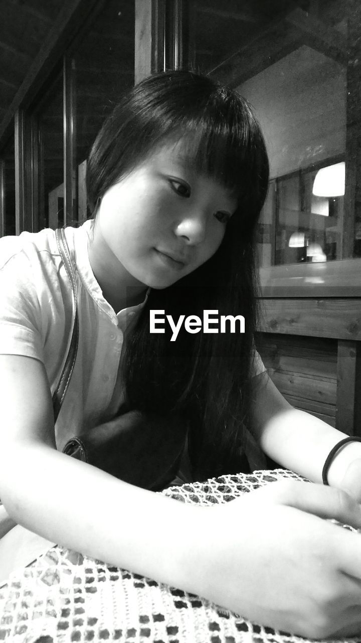 Teenage girl looking away while sitting at table