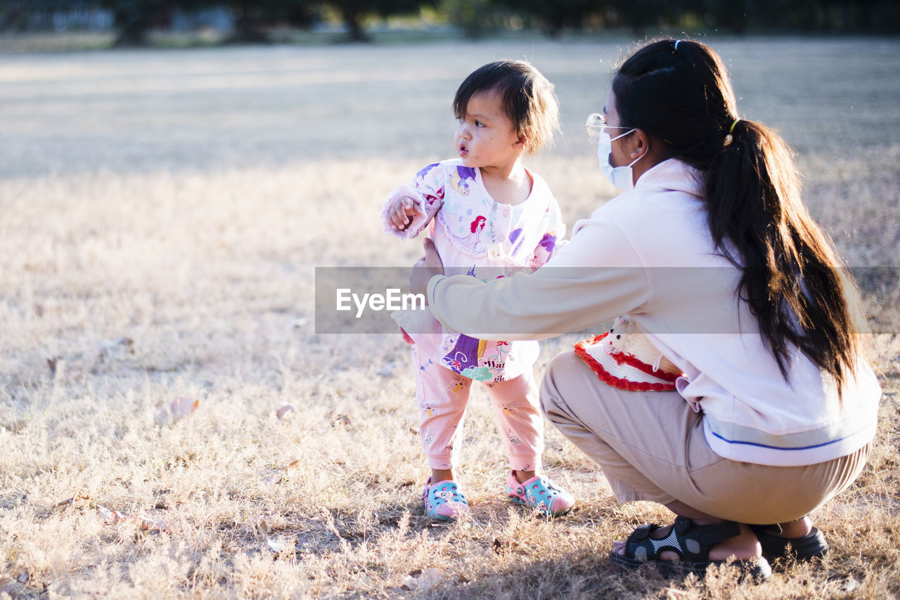 women, female, child, childhood, adult, togetherness, spring, two people, family, emotion, nature, portrait photography, positive emotion, land, parent, happiness, full length, love, person, ceremony, smiling, clothing, lifestyles, bonding, one parent, cute, casual clothing, plant, baby, toddler, hairstyle, sunlight, leisure activity, outdoors, day, romance, sitting, dress, long hair