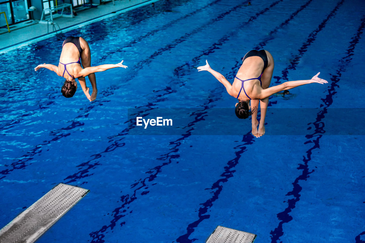 Female athletes jumping in swimming pool