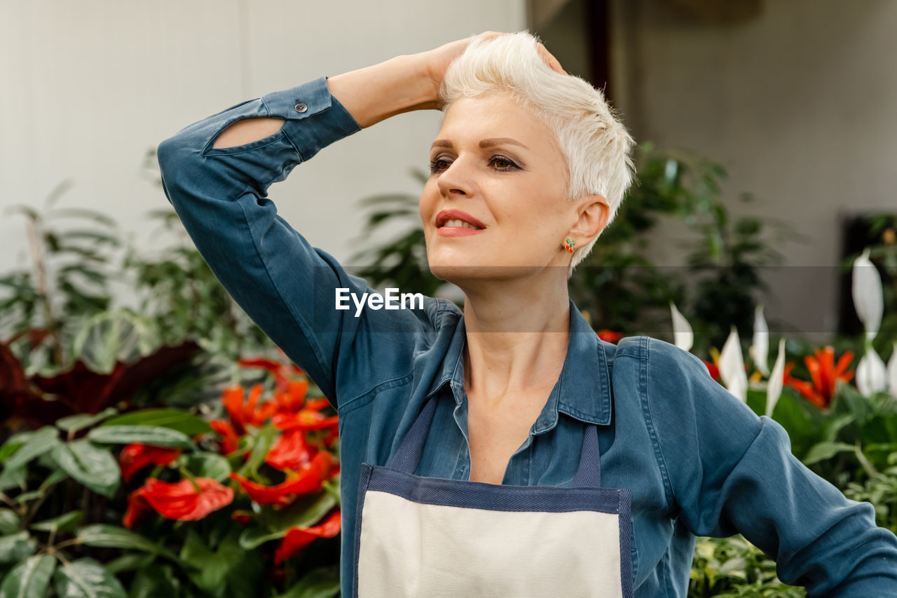 Smiling middle aged female model with house plant. agriculture