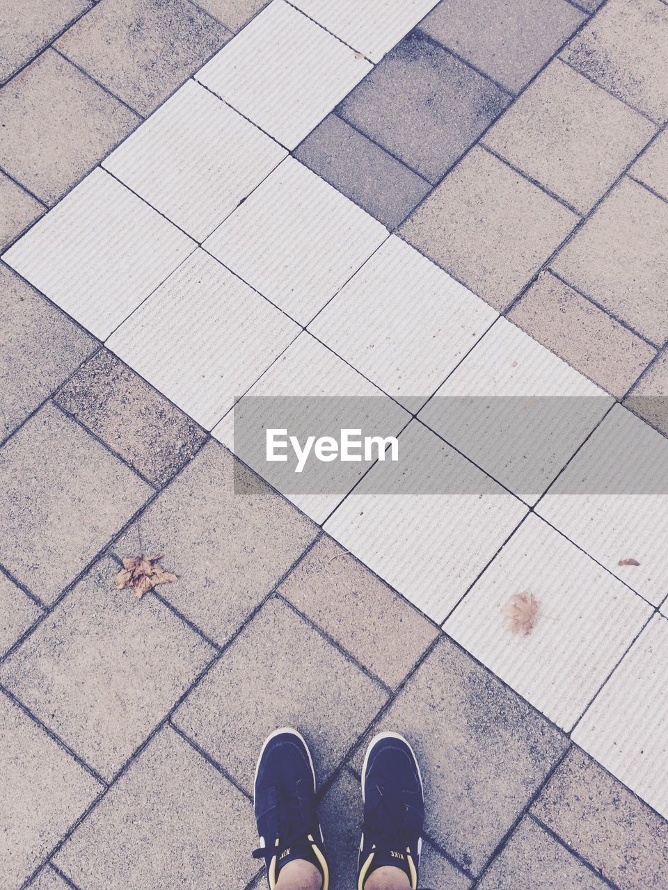 Low section of man standing on concrete floor