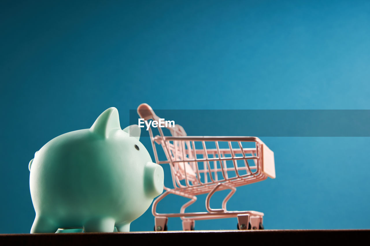 Piggpabk and shopping cart on blue background
