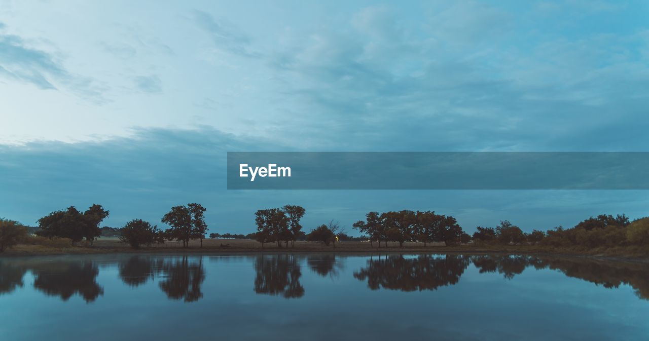 Reflection of trees in lake against sky