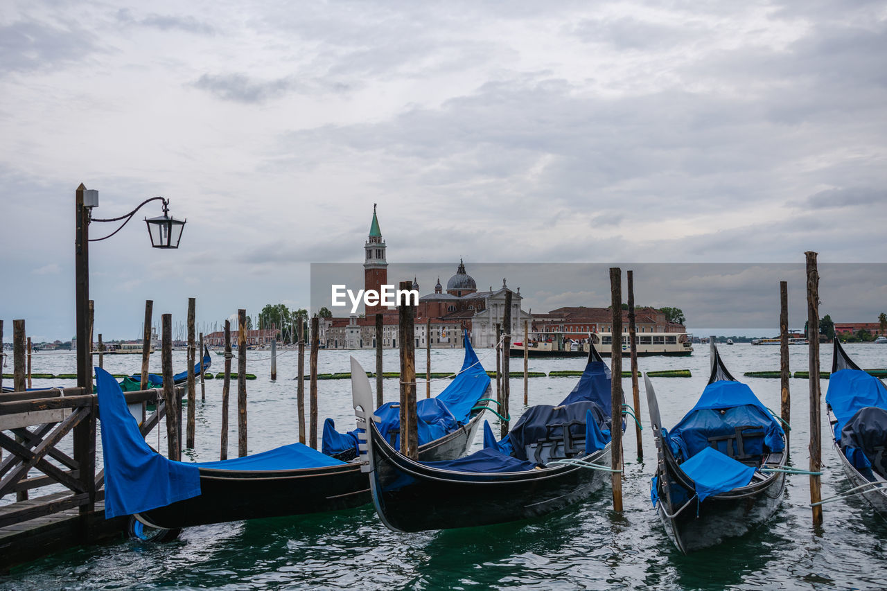 gondola, nautical vessel, water, transportation, mode of transportation, boat, travel destinations, vehicle, travel, boating, architecture, canal, sea, nature, watercraft, tourism, sky, building exterior, lagoon, cloud, city, wooden post, moored, romance, trip, holiday, built structure, place of worship, vacation, bell tower, idyllic, religion, beauty in nature, scenics - nature, tower, outdoors, post, love, wood, mooring post, gondolier, ship, tranquility
