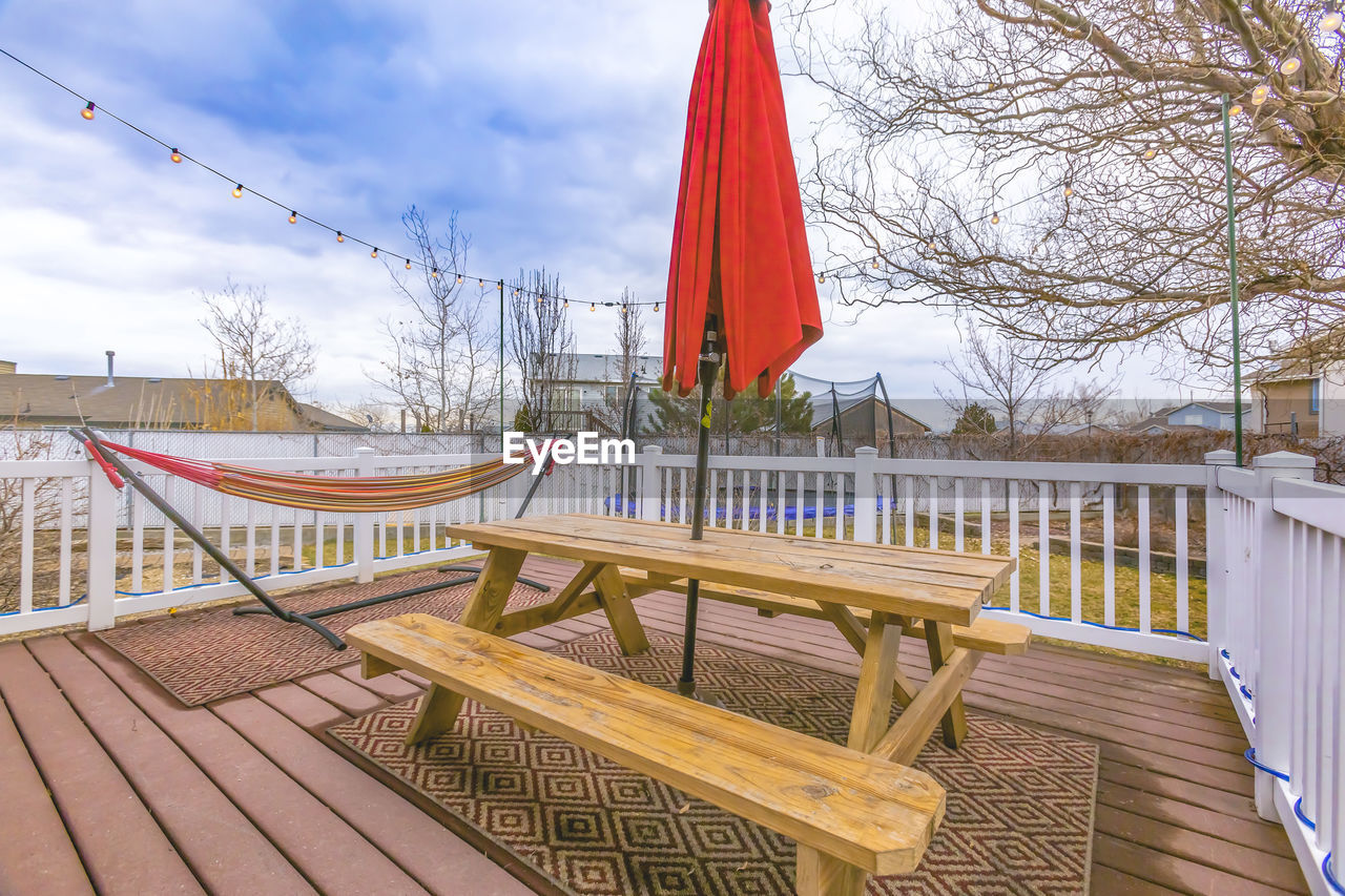 EMPTY CHAIRS AND TABLES AGAINST SKY