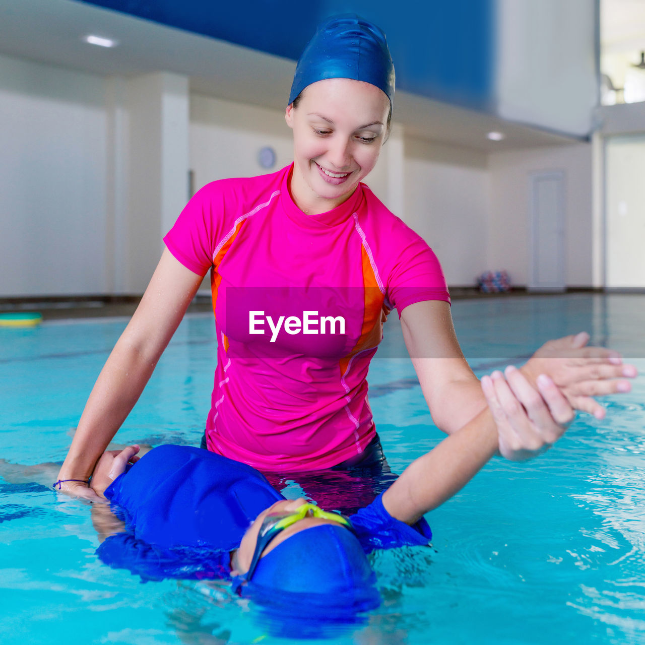 Mother teaching swimming to son in pool