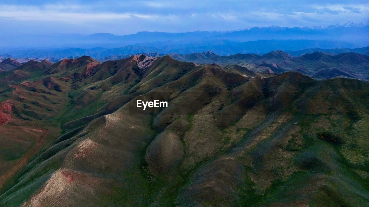 landscape, environment, scenics - nature, mountain, wilderness, land, nature, beauty in nature, sky, ridge, mountain range, travel destinations, no people, cloud, travel, valley, plateau, non-urban scene, terrain, outdoors, panoramic, rock, tranquility, plant, tranquil scene, tourism, rural scene, high angle view, geology, day, multi colored, social issues, mountain pass