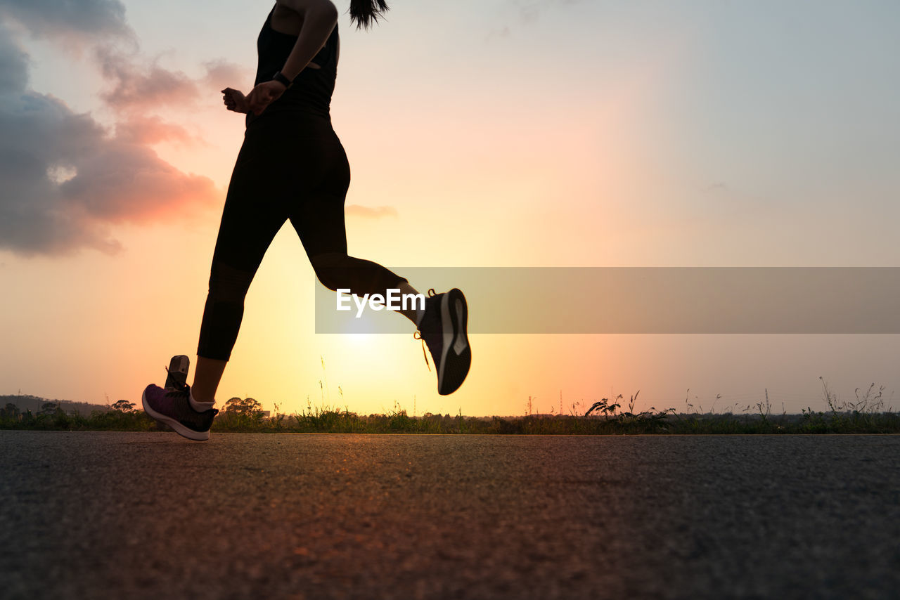 Sport woman running on a road. fitness woman training at sunset