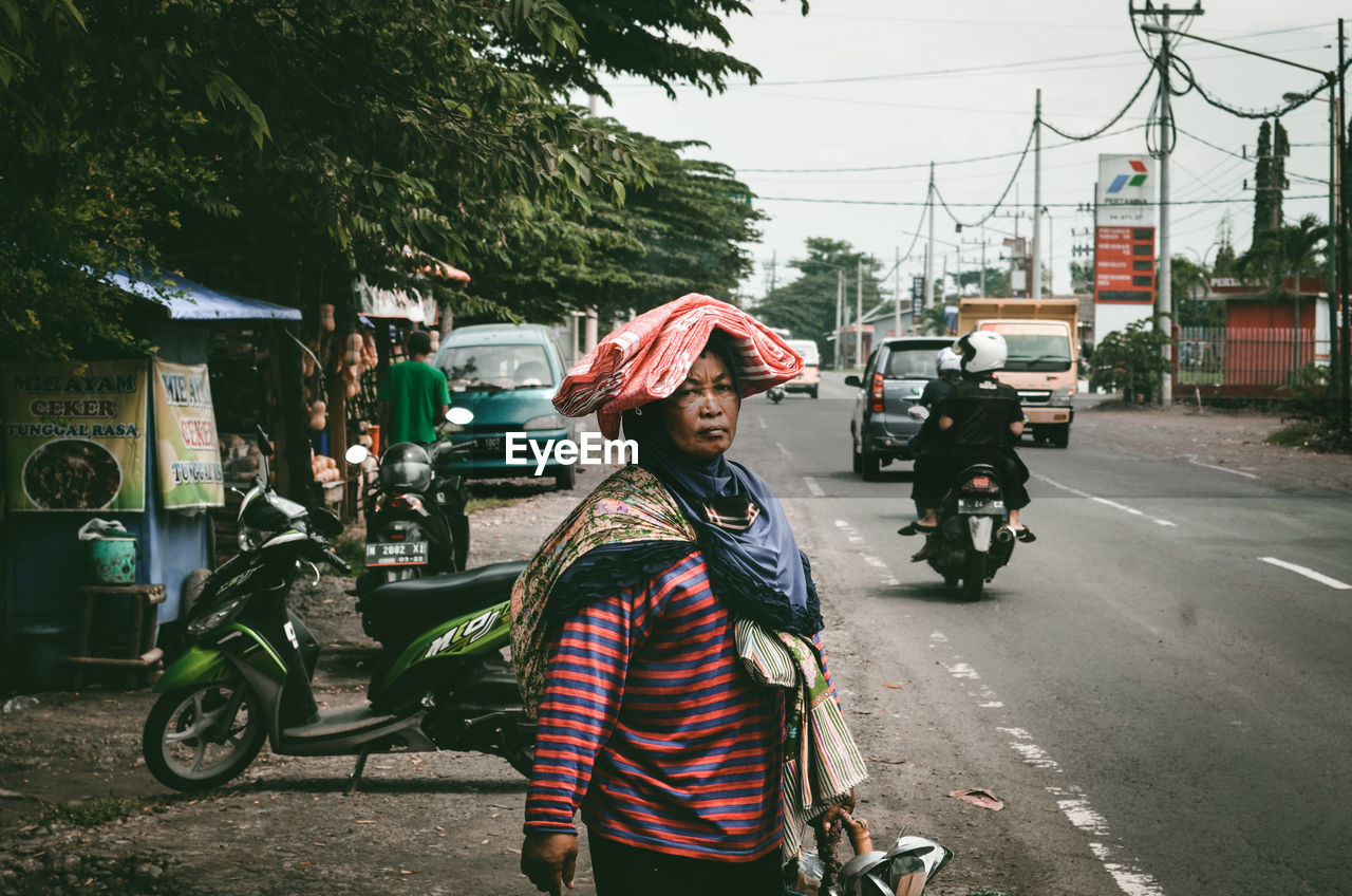 WOMAN RIDING BICYCLE ON ROAD