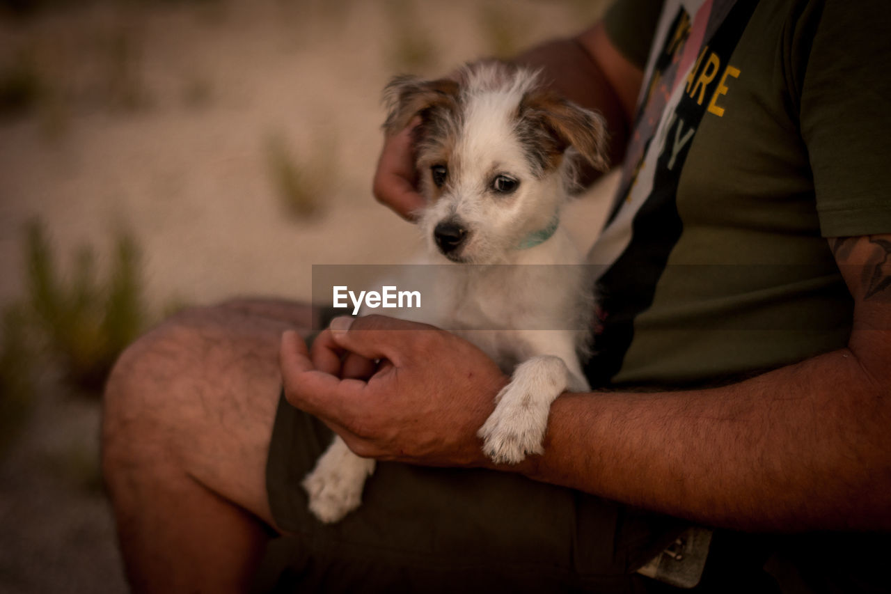 MIDSECTION OF MAN HOLDING DOG WITH MOUTH OPEN