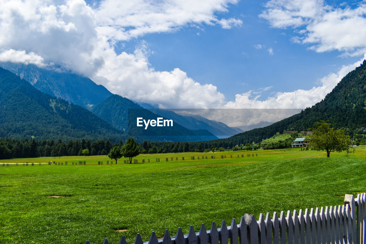 An eye catching beautiful mountains surrounds a beautiful golf course at pahalgam kashmir, india.