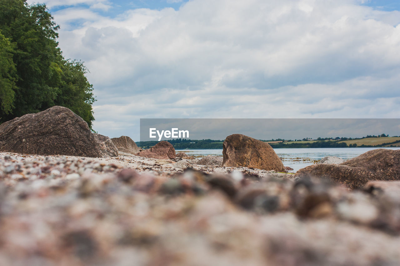 Surface level of rocks on beach against sky