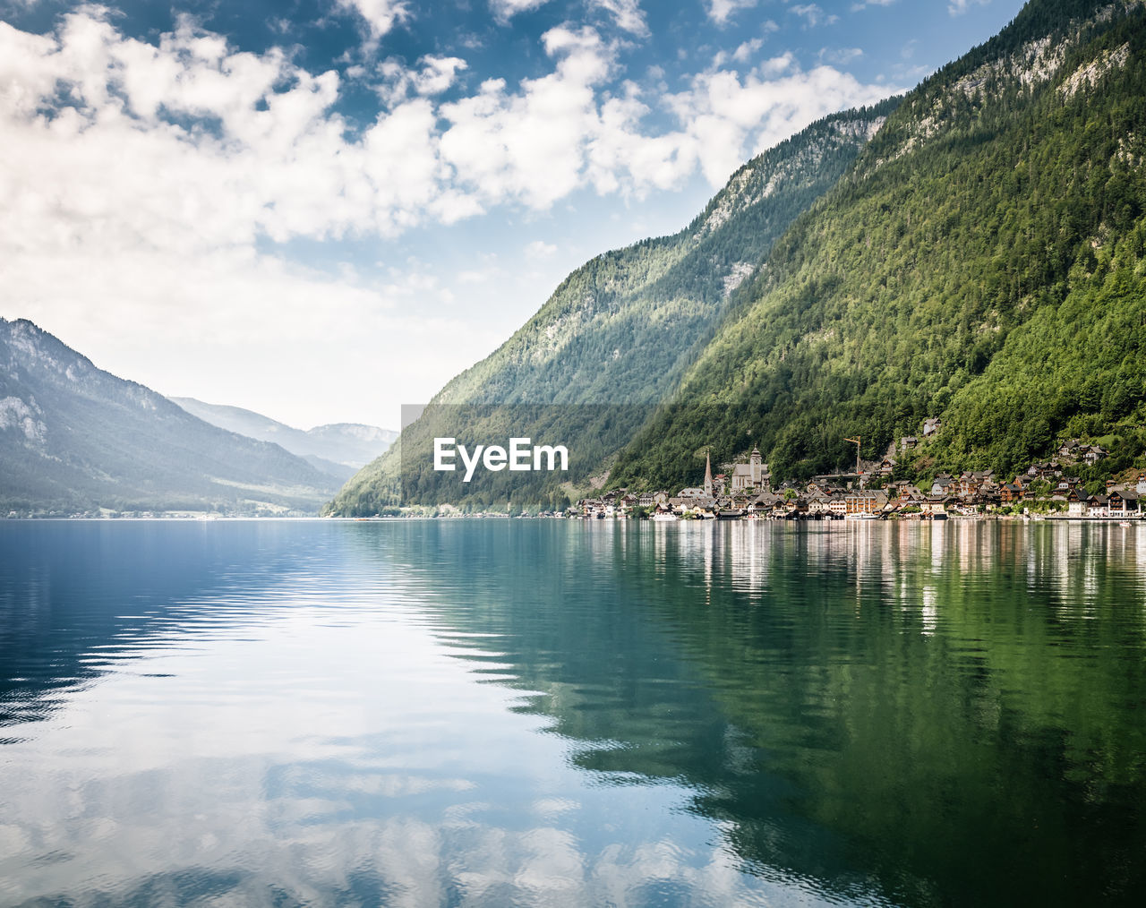 Surface level view of calm lake surrounded by mountain village