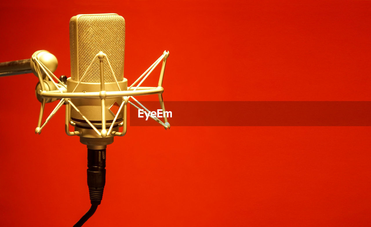 Close-up of microphone against red background