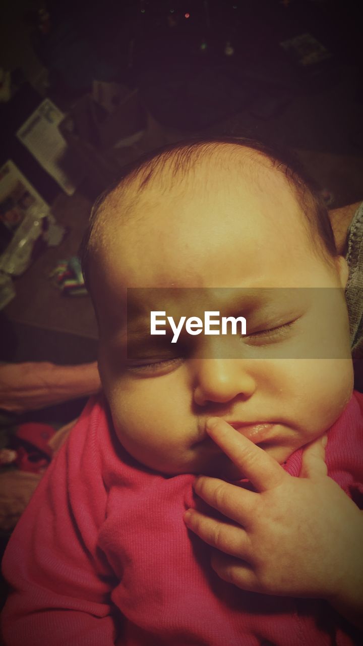 Close-up of cute baby girl sleeping at home