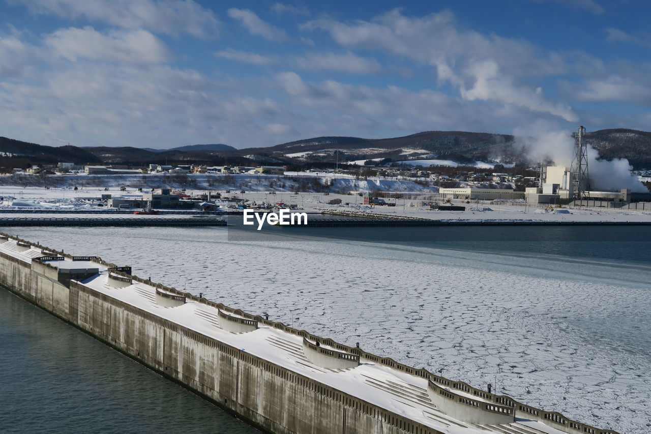 Scenic view of sea by city against sky