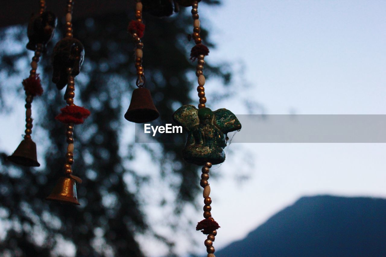 Low angle view of wind chime hanging against sky